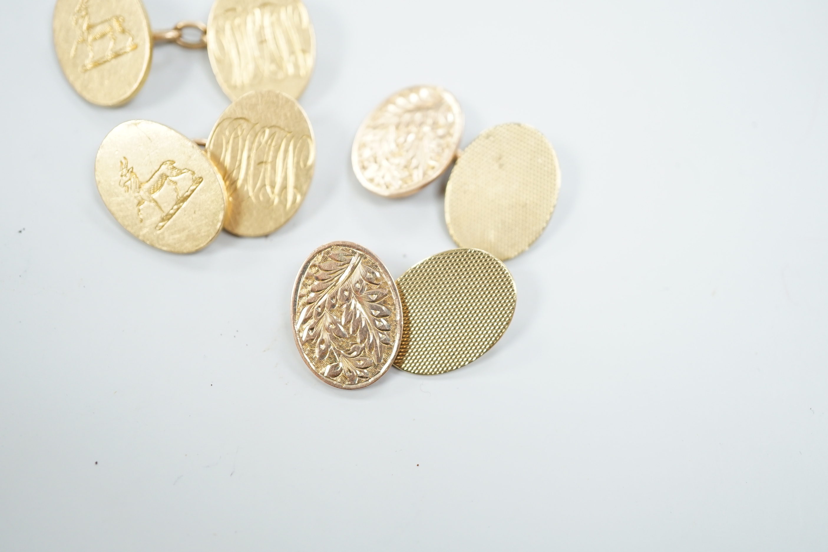 A pair of George V 18ct gold oval cufflinks, with engraved crest and initials, G.H. Johnstone & Co, Birmingham, 1915, 16.7 grams and a pair of late Victorian engraved 9ct gold oval cufflinks, 6.7 grams.